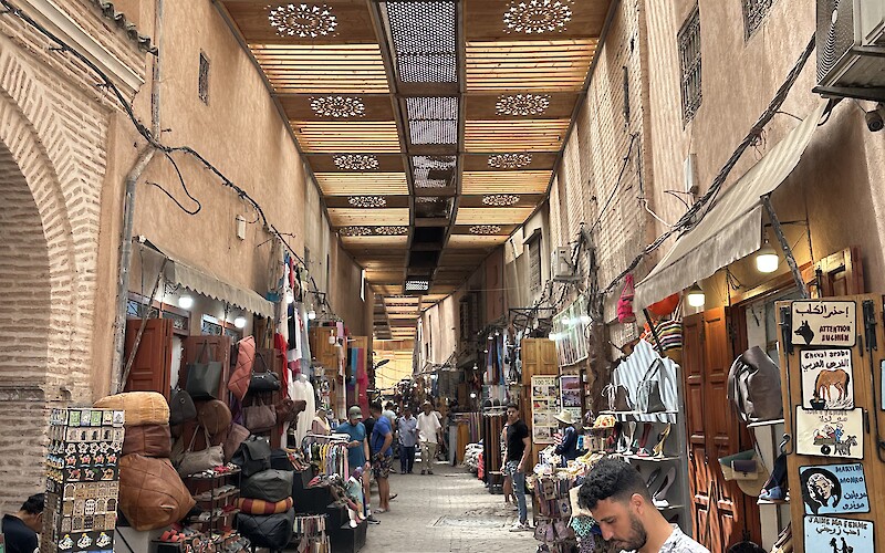 An alley filled with colorful shops selling jewelry, clothes, belts, and endless other…