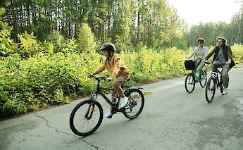 Child enjoying a bike ride with family. Getty Images@Unsplash