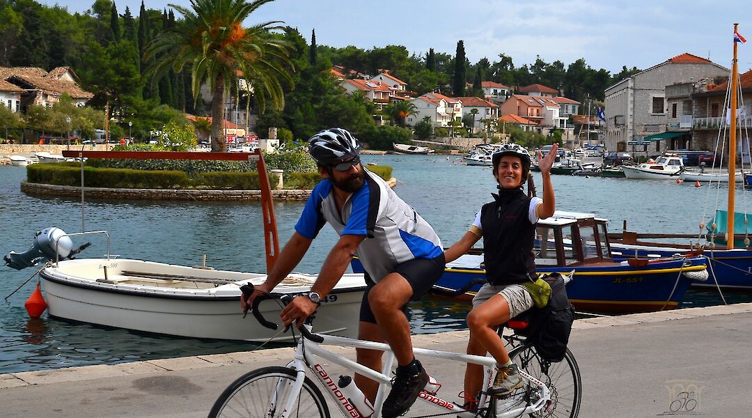 Two cyclists riding along the waterfront in Dalmatia, Croatia
