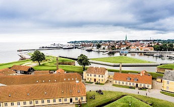 Aerial view of Kronborg Castle in Helsingør, Denmark, with surrounding water and town in the background.