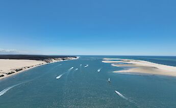Aerial view of boats on a waterway surrounded by sandy shores in Talmont-sur-Gironde, France.