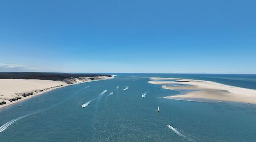 Aerial view of boats on a waterway surrounded by sandy shores in Talmont-sur-Gironde, France.