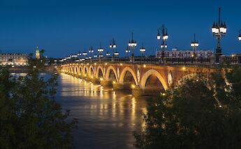 Bridge illuminated at night, Bordeaux, France. Unsplash:Pierre Blache