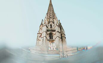 View of a detailed cathedral spire reaching into the sky in Gironde, France.