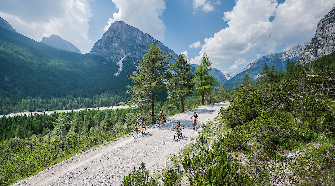 Riding a gravel track high in the Dolomites with sweeping valley views. -toFA