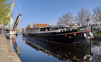 Merlijn boat is seen in a canal near Haarlem with a raised drawbridge in the background on a clear&hellip;