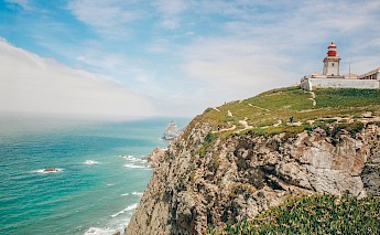 A lighthouse on a clifftop overlooking the ocean at Cabo da Roca, Portugal.