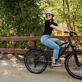 Woman smiling on electric bike. Unsplash:KBO Bike
