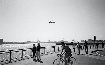 Cyclist and pedestrians along the waters edge in NYC. Unsplash:Gemma Evans