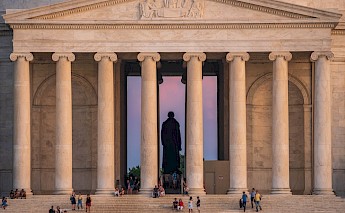 People taking break from sightseeing on the steps of Jefferson Memorial at the National Mall, DC. Flickr:John Brighenti