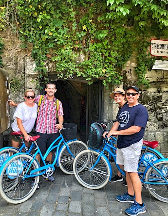 Tour participants with bicycles in front of an ivy-covered entrance at Strossmayer Promenade, Zagreb.