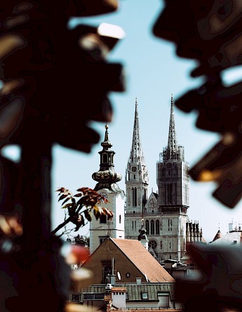 Cathedral in Zagreb, through tree leaves. Unsplash:Jason Blackeye