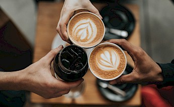 Coffee cheers. Unsplash:Nathan Dumlao