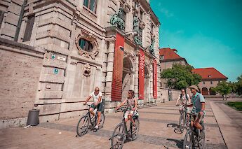 Biking past historic buildings, Munich, Germany. CC:Radius Tours
