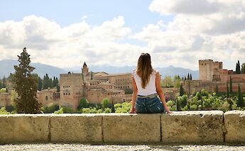 Woman sitting on a wall in Granada, Spain. Unsplash:Jorge Fernandez Salas