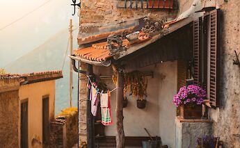 Stone house located at a narrow street, Tuscany. Unsplash:Redcharlie