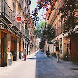 Pedestrian street with shops in downtown Madrid. Unsplash: Alex Vasey
