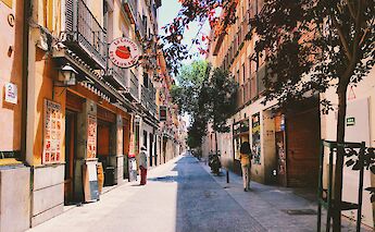 Pedestrian street with shops in downtown Madrid. Unsplash: Alex Vasey