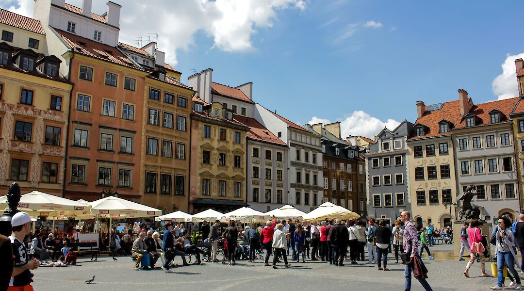 People walking through a square, Warsaw, Poland. Unsplash:Fikri Ahmad Maulana