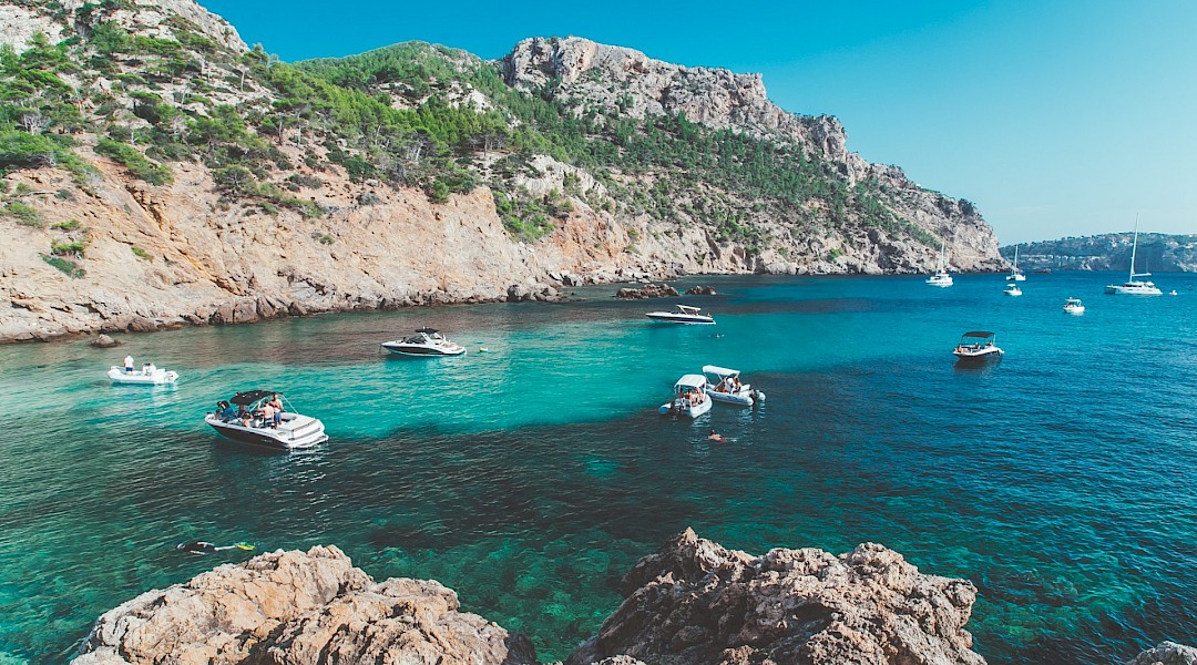 Boats anchored in a crystal azure water bay, Palma de Mallorca. Unsplash:Eugene Zhyvchik