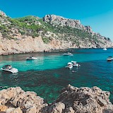 Boats anchored in a crystal azure water bay, Palma de Mallorca. Unsplash:Eugene Zhyvchik