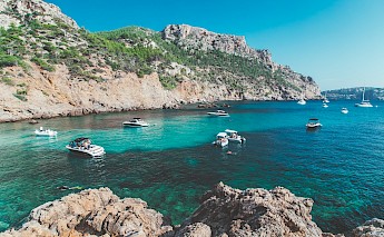 Boats anchored in a crystal azure water bay, Palma de Mallorca. Unsplash:Eugene Zhyvchik