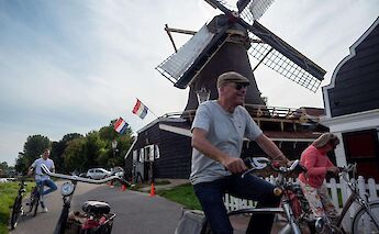 Cycling past windmills in the Dutch countryside, Amsterdam, Holland bike tour. CC:TO