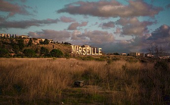 Marseille sign in white letters, against the gold sky. Ray Tiller@Unsplash