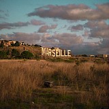 Marseille sign in white letters, against the gold sky. Ray Tiller@Unsplash
