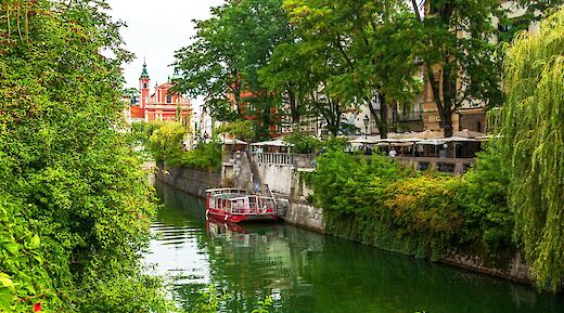 The river Ljubjanica in full bloom, with the red Franciscan Church of the Annunciation in the background. Eugene Kuznetsov@Unsplash