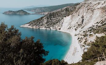 White sand beach with rocky mountains, Kefalonia. Unsplash: Eleanor Brooke