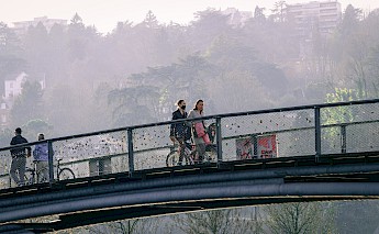 People on a bike crossing the Lyon's Confluence footbridge. Baptiste Buisson@Unsplash