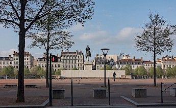 Pedestrian passing by the Place Bellecour, Lyon, France. Touam@Wikimedia Commons