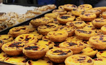 A pile of traditional Portuguese custard tarts, known as pastéis de nata, on display.