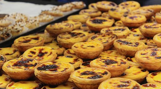 A pile of traditional Portuguese custard tarts, known as past&eacute;is de nata, on display.
