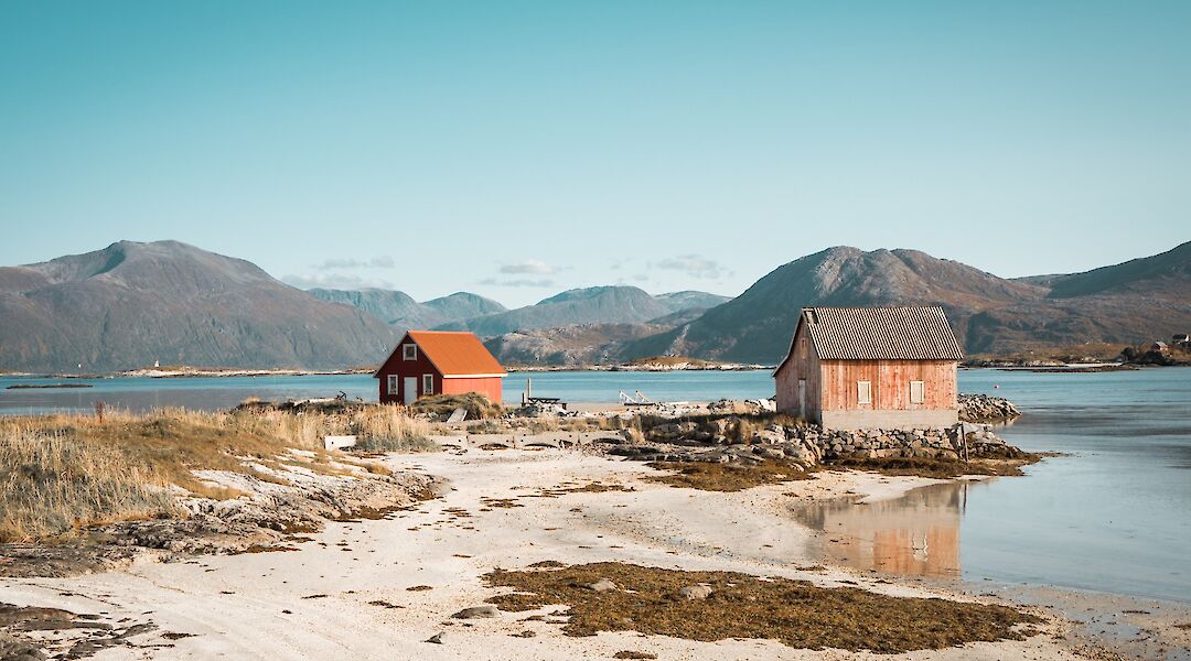 Wooden cottages at a beach in Tromso, Norway. Thomas Claeys@Unsplash