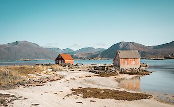 Wooden cottages at a beach in Tromso, Norway. Thomas Claeys@Unsplash