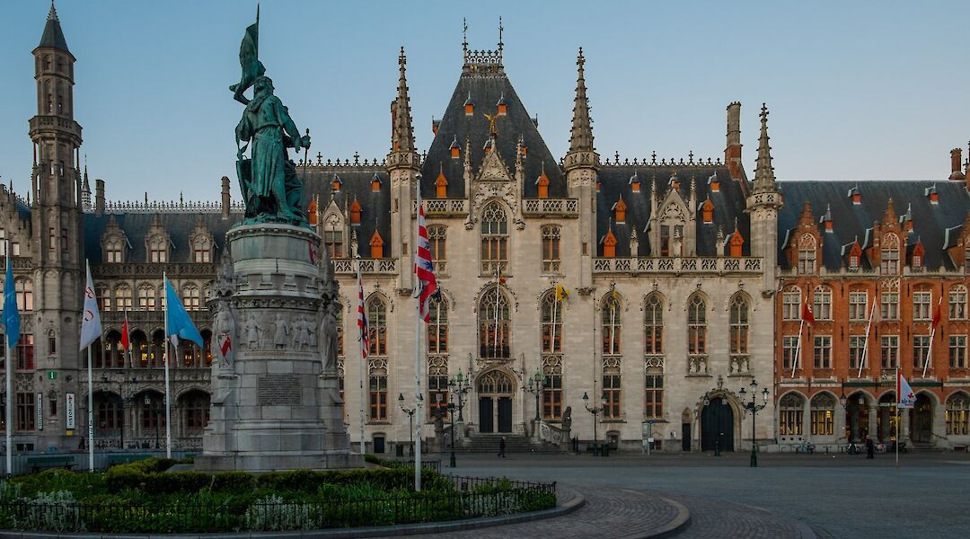 Flags and a statue in the middle of Bruges Square, Bruges, Belgium. Elijah G@Unsplash