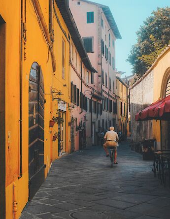 Man cycling, Lucca, Italy. Unsplash:Cristina Gottardi