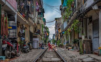 Man in a red chair on Train Street, Hanoi, Vietnam. Chor Tsang@Unsplash