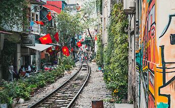Flags displayed outside households along Train Street in Hanoi, Vietnam. Silver Ringvee@Unsplash