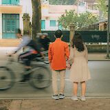 Bike rider passing by a couple in the streets of Hanoi, Vietnam. Huyen Pham@Unsplash