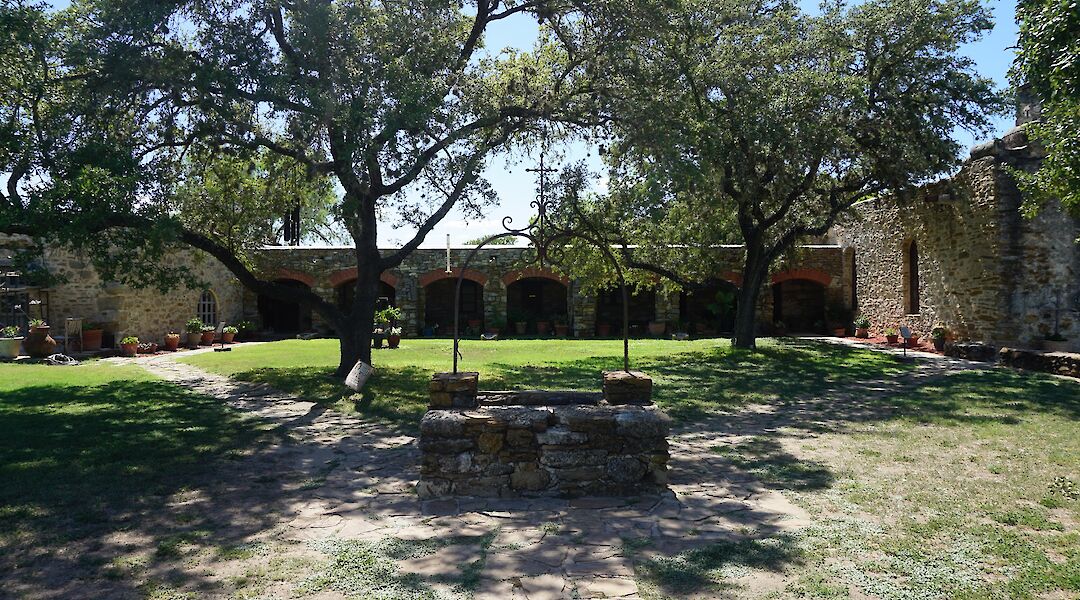Trees and an old well outside Mission Espada, San Antonio, Texas, USA. CC:Michael Barera