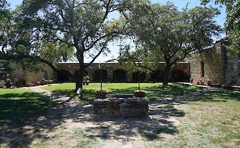 Trees and an old well outside Mission Espada, San Antonio, Texas, USA. CC:Michael Barera