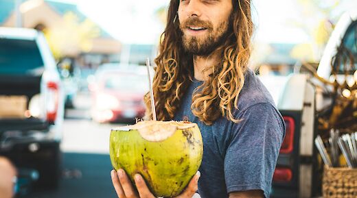 Hawaiian local presents a coconut to a customer. Chloe Leis@Unsplash