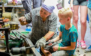 Young bike tourist learning local trade, Bangkok Thailand. Grasshopper Day Tours