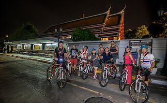 Bike tourists outside a temple at night, Bangkok, Thailand. CC:Grasshopper Day Tours