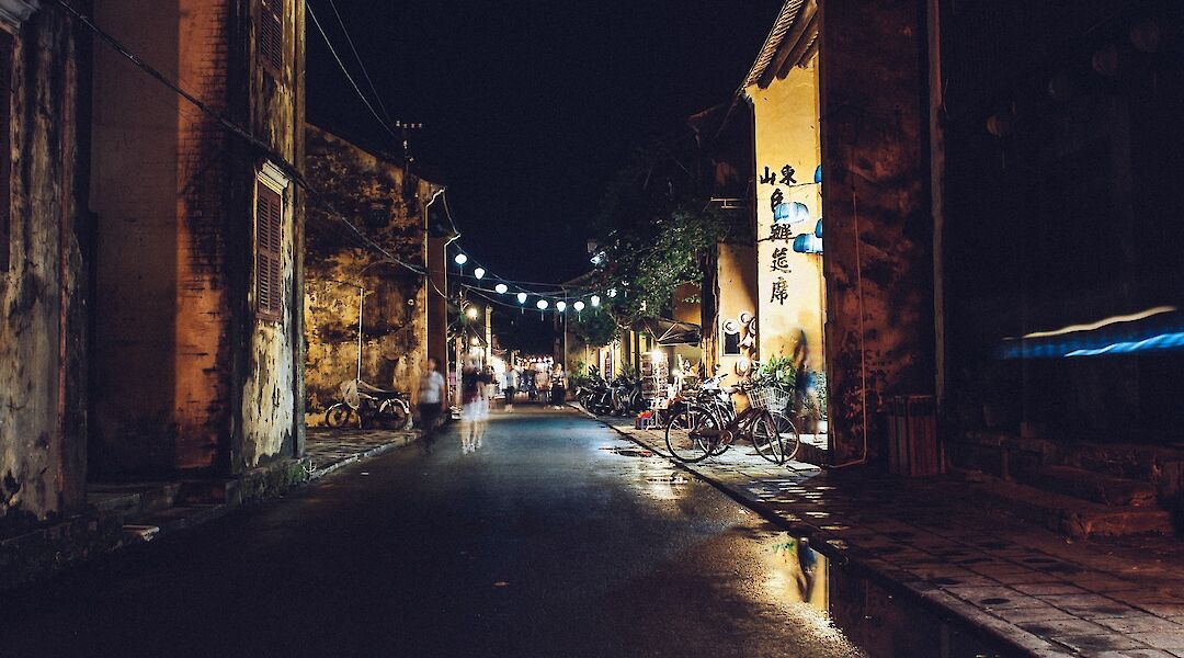 Bikes, pedestrians, and lanterns on the evening streets of Hoi An, Vietnam. Rafael Fabricio@Unsplash