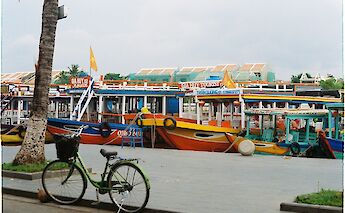 Colorful tourist boats and a bike in Hoi An, Vietnam. Le Porcs@Unsplash
