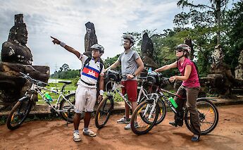 Knowledgeable guide providing historical lecture to riders, Siem Reap, Cambodia. Grasshopper Day tours
